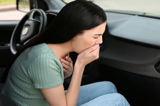 Žena s nevolnostmi během jízdy autem.