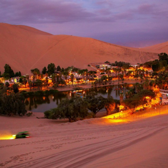 Vesnice Huacachina po západu slunce.