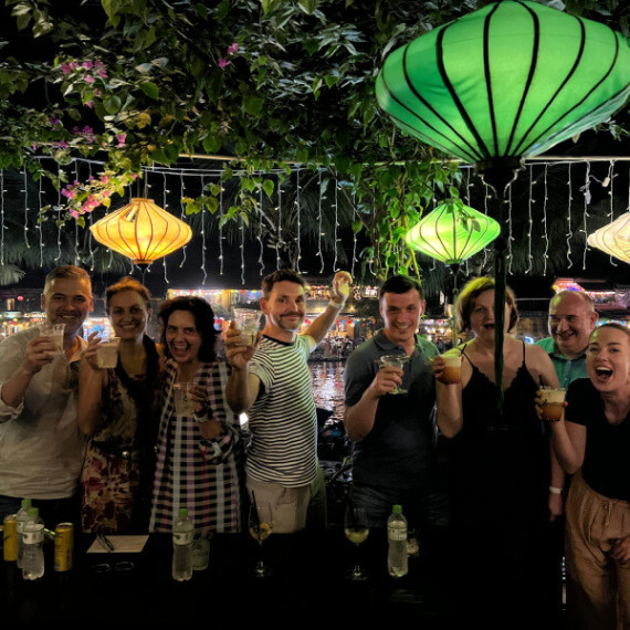 : Účastníci zájezdu CK SEN si připíjí pod lampiony v Hoi An u řeky.