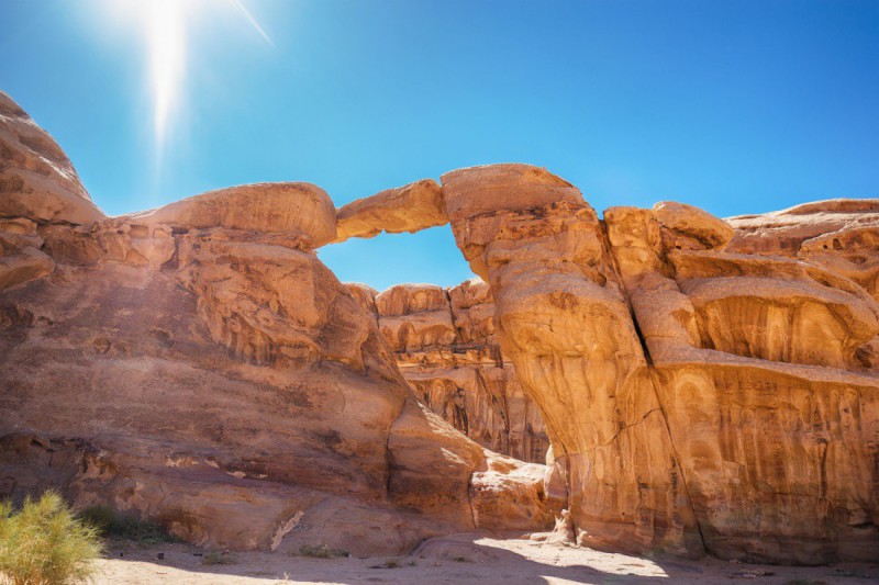 Jasná obloha nad skalním mostem ve Wadi Rum.