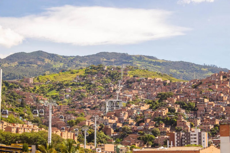 Známé kolumbijské město Medellín s lanovkovou dopravou je v obležení kopců posetých typickými domy.  