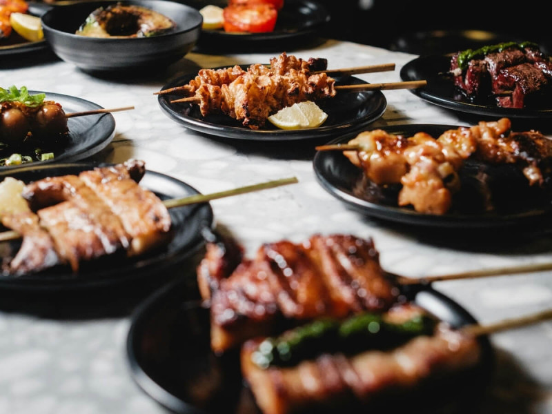 Grilované špízy Yakitori na talířích.