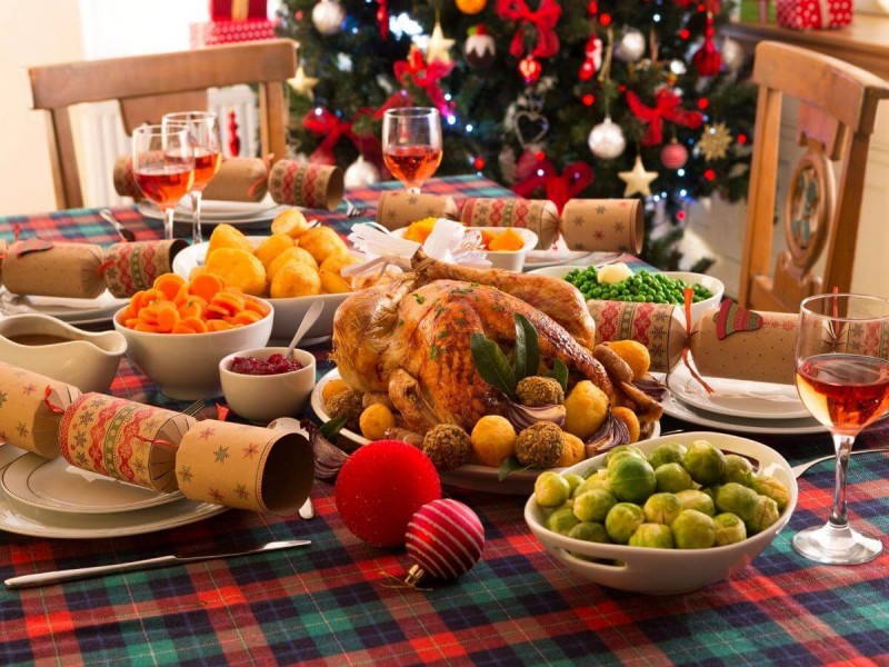 Americký vánoční stůl s pečeným krocanem, pečenými brambory, zeleninou a omáčkami.