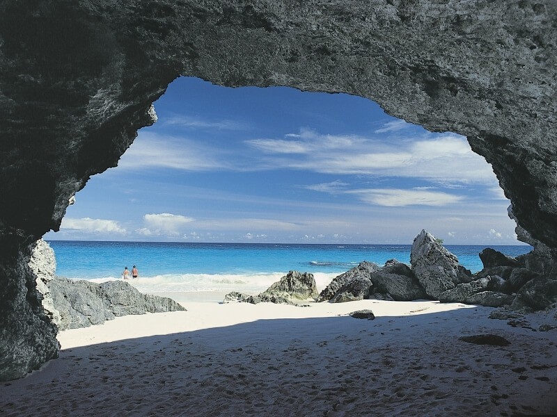 Pláž s tyrkysovou vodou a bílým pískem na Bermudách.