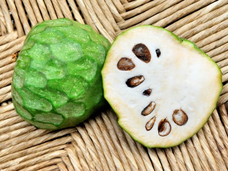 Bílá dužina s černými semínky ovoce cherimoya.