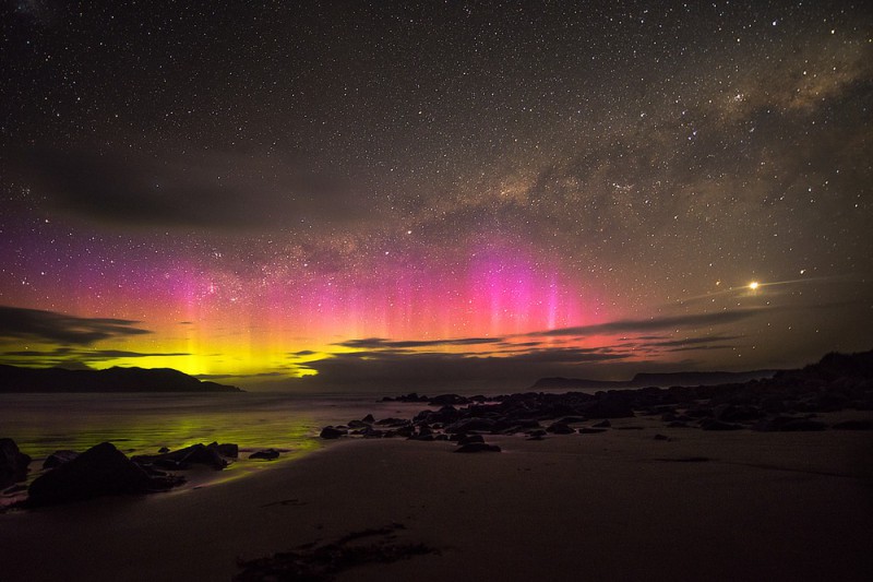 Polární záře odrážející se nad vodou v Strahan, Austrálie.