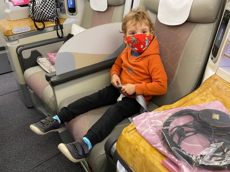 Malé dítě s rouškou na tváři v letadle.