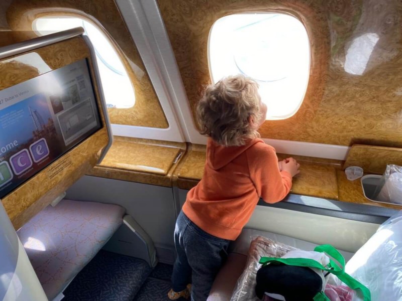 Dítě dívající se z okna během cesty letadlem.