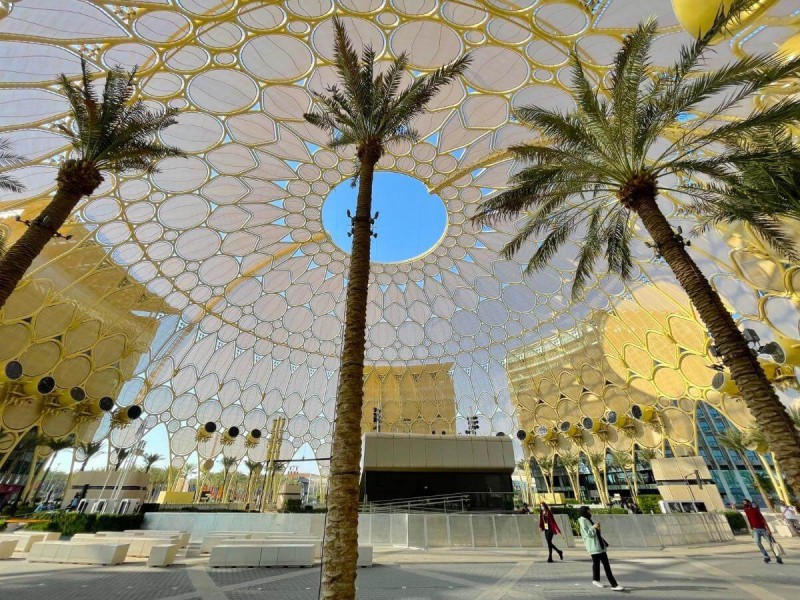 Zlatá kupole Al Wasl Dome a vysoké palmy na Expo Dubai 2020.