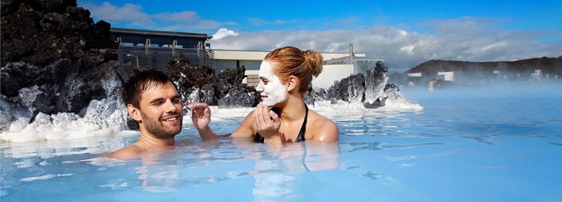 Mladý pár dávající si masku na tvář v Modré laguně na Islandu.