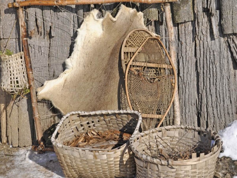 Proutěné košíky a jiné artefakty ve zrekonstruované vesnici kmene Iroquois.