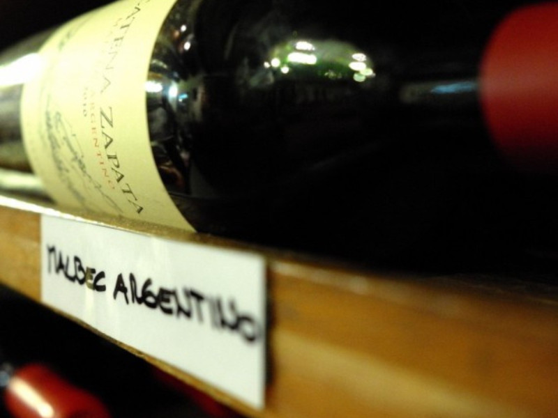 Víno Malbec Argentino na dřevěném stojanu.