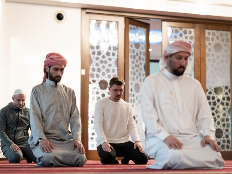 Muslimové a turisté při návštěvě mešity.
