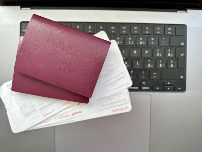 Letenky a pasy položené na klávesnici notebooku. 