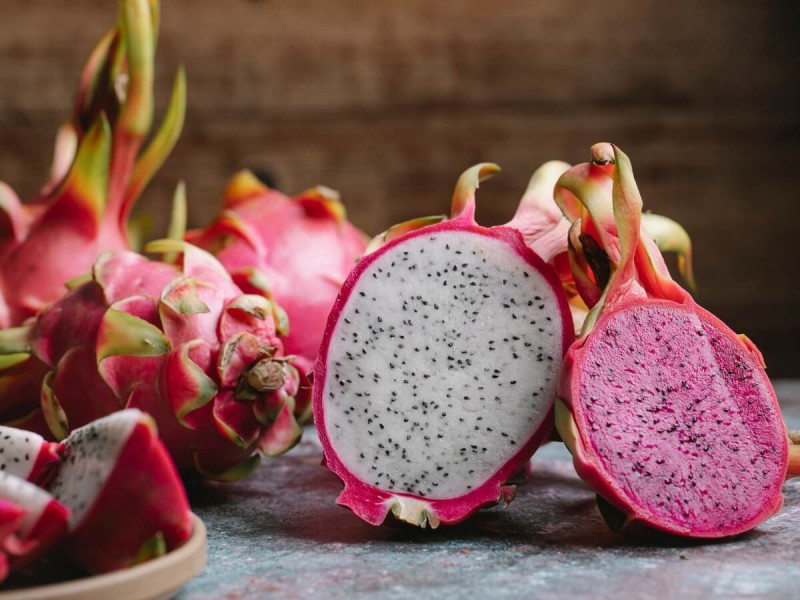 Bílá a růžová dužina překrojeného dračího ovoce pitaya.