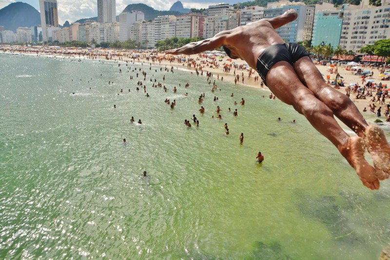 Muž skákající šipku na pláži Copacabana.