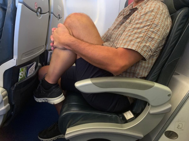 Přitahování kolen k hrudníku během sezení v letadle.