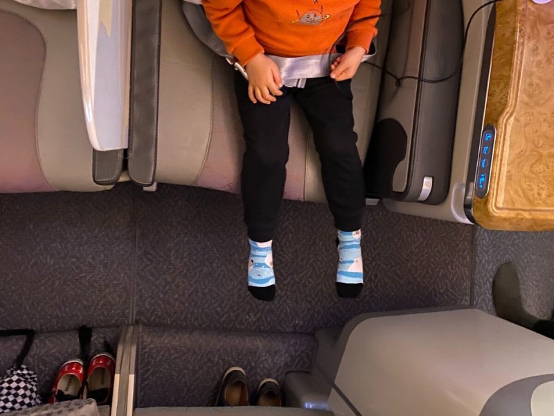 Nohy dítěte a prostor pro nohy v letadle v business class.