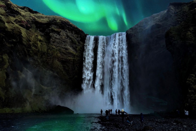 Polární záře nad vodopádem Skógafoss, Island.