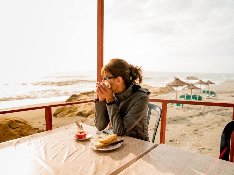 Žena na snídani na pláži.