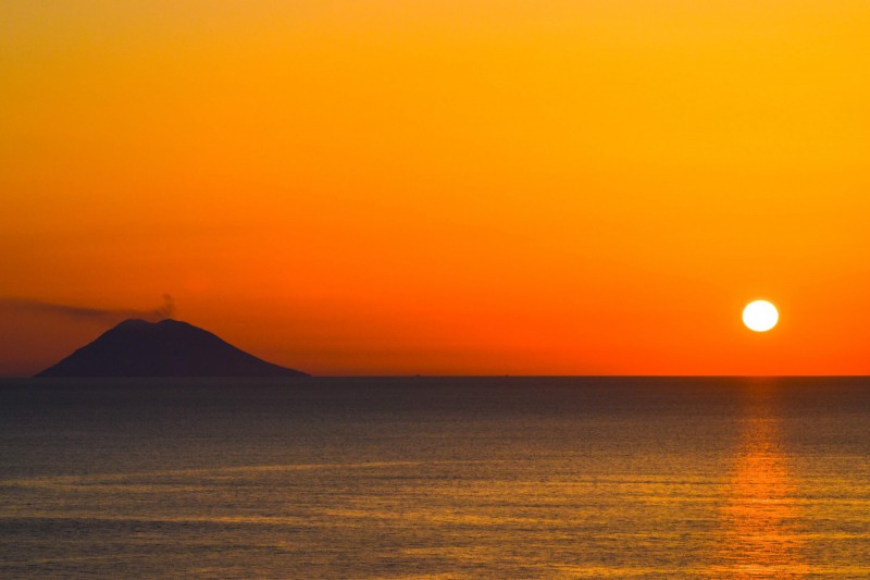 Západ slunce a pohled na sopku Stromboli v Itálii