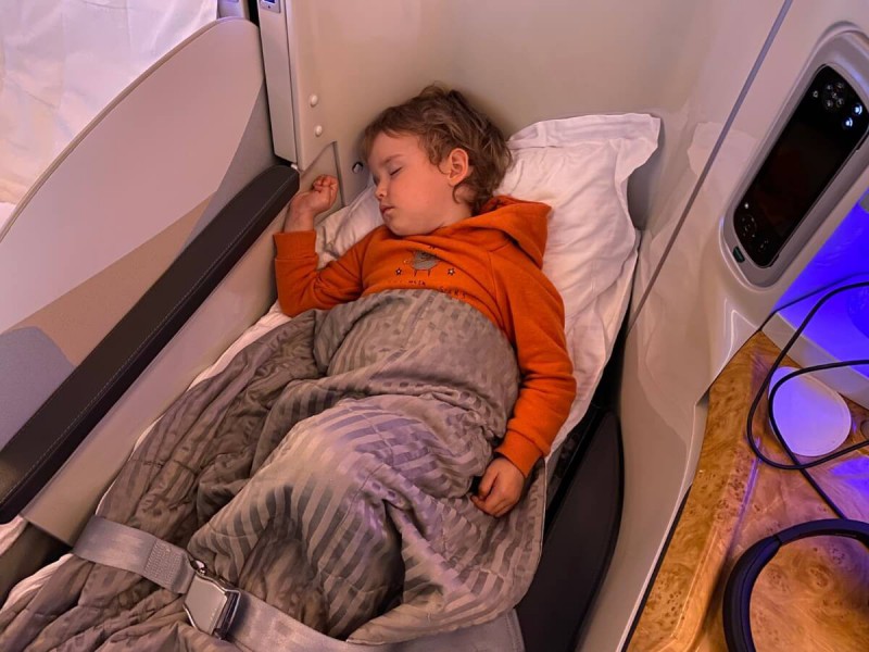 Spící dítě v letadle v business class.