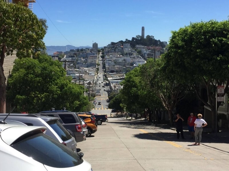 Strmé ulice v San Franciscu a v pozadí Coit Tower.
