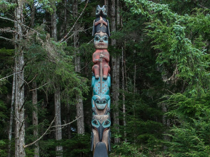Dřevěný totem Tlingit u lesa v Sitce, Aljaška.