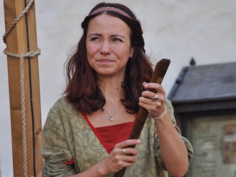 Žena s flétnou v tradičním oblečení.