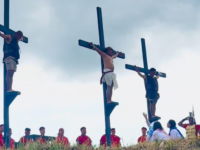 Symbolické ukřižování – tři Filipínci visí na kříži během velikonočního rituálu na Filipínách.