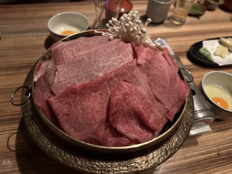 Wagyu sukiyaki s vajíčky a houbami enoki.