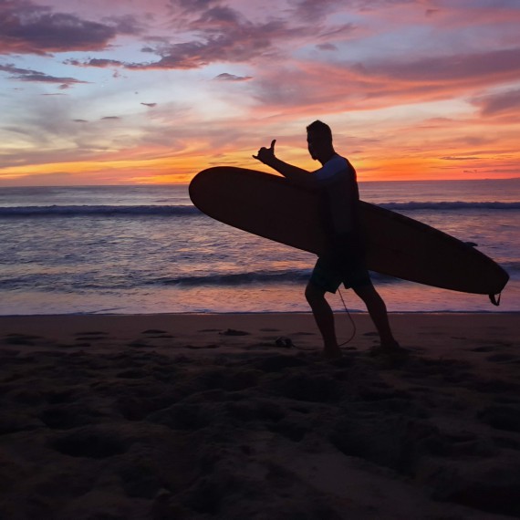 Surfař na pláži v Kostarice 