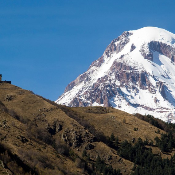 Ikonický klášter Tsminda Sameba a zasněžený vrch hory Kazbeg, kde podle legendy spočívá Prométeus