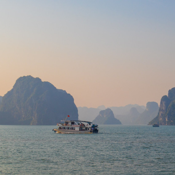Loď pluje mezi majestátními skalami zátoky Ha Long Bay
