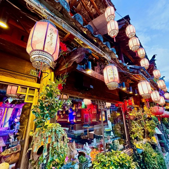 Dřevěné domečky s taškovými střechami a červenými lampiony. 