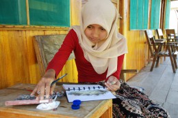 Místní dívka kreslí vesnici Waerbo