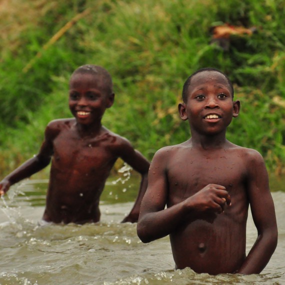 Místní děti při vodních hrátkách, Uganda