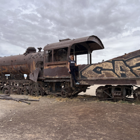 Naše SEN průvodkyně na vraku lokomotivy v poušti Uyuni v Bolívii.