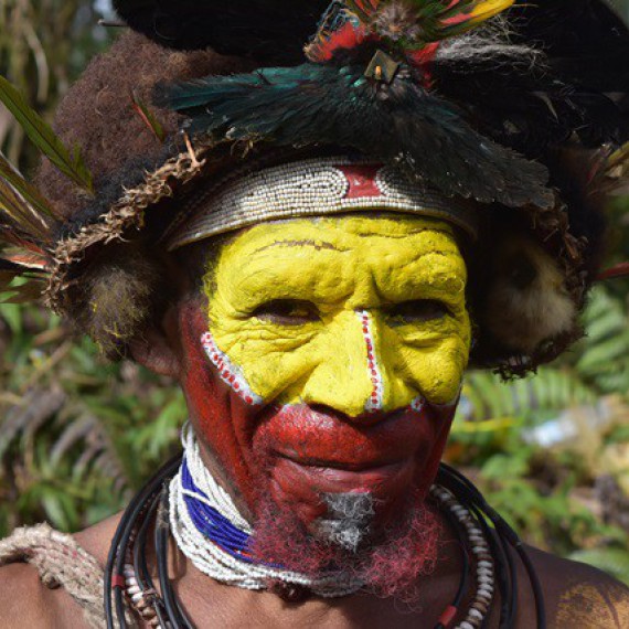 Žluté tváře lidí z kmene Huliů na Papue